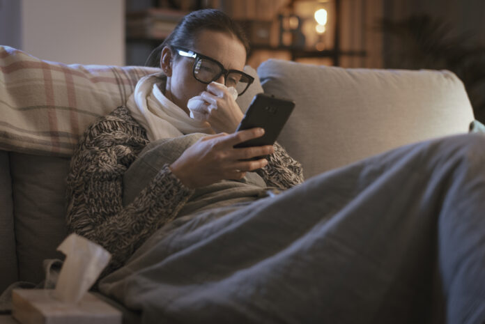 Sick woman resting on the couch and connecting with her smartphone Your Phone Screen Destroys Melatonin